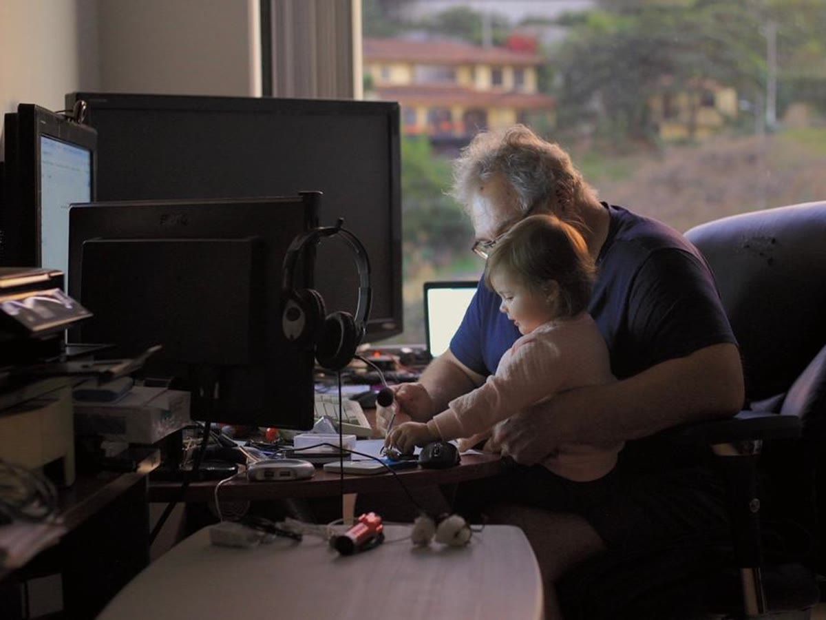El papá de Irene Rosich con su nieta frente a la computadora.